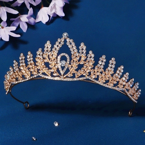 Elegant gold bridal crown with crystal leaf patterns on a dark blue background