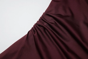 Vue macro du tissu plissé rouge bordeaux avec texture froncée élégante et fini soyeux
