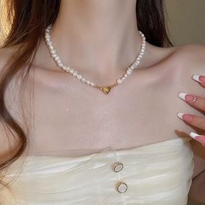 Detail of 18K gold heart pendant on irregular freshwater pearl beaded necklace