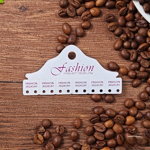 Close-up of 5x9.8cm white cardboard jewelry display card with 12 holes for earrings