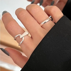 Close-up of elegant 925 silver rings with a minimalist band and horseshoe D-buckle detail