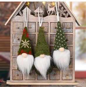 Three Christmas gnomes with knitted hats and white plush beards hanging as festive decorations