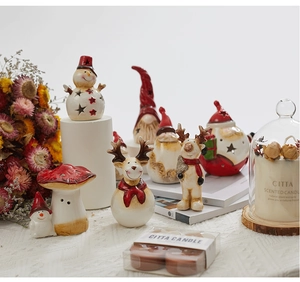 Detailed view of Christmas ceramic snowman and reindeer decor with scented candles