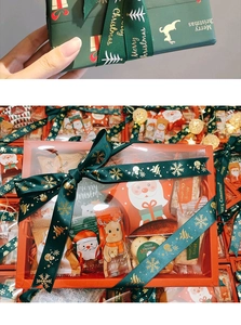 Detail of red and green Merry Christmas gift boxes with gold foil ribbons and bows