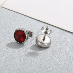 Vue macro de boucles d'oreilles clous en cristal rouge avec monture en acier poli