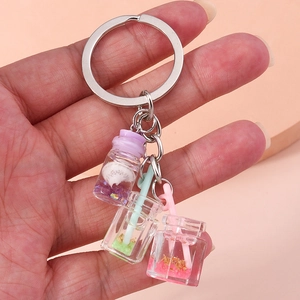 Close-up of mini fruit drink bottle charms in purple, green and pink on a silver keychain