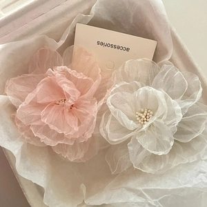 Pink and white chiffon camellia hair clips with mesh details on a minimalist card