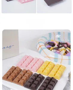 Vue à plat de breloques en chocolat colorées en rose, marron et jaune avec trous de suspension