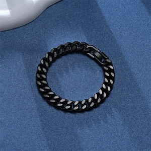 Close-up of black metal Cuban chain bracelet with woven design on blue background