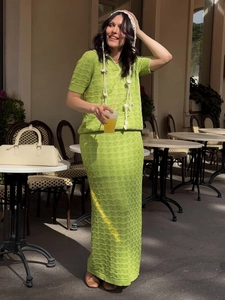 Detail of lime green knit crochet two-piece set featuring hollow wave patterns and texture
