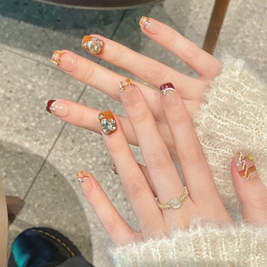 Handmade press-on nails featuring amber plaid patterns and sparkling crystal rhinestones