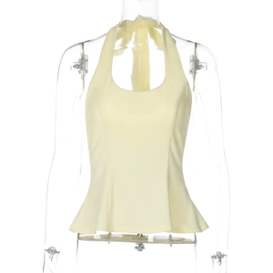 Detail of light yellow halter top featuring slim fit waist and flared peplum hem design