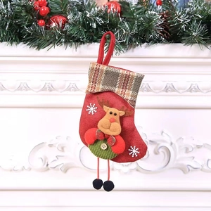 Close-up of a red fabric Christmas stocking featuring a 3D reindeer doll and plaid cuff
