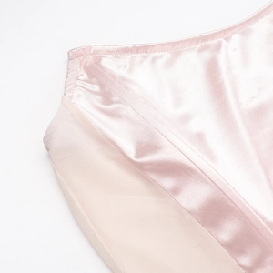 Detail of light pink satin and mesh fabric splicing on a sleek formal dress