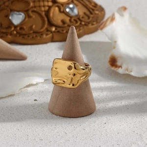 Retro 18k gold plated stainless steel ring with minimalist lava texture on a stand