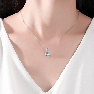 Elegant S925 sterling silver necklace with blue teardrop pendant on a model