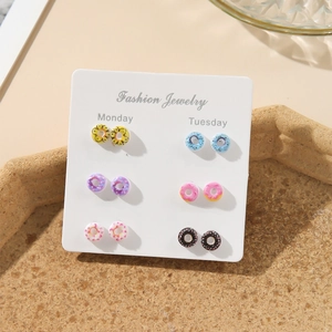 Close-up of 6 pairs of colorful donut stud earrings organized on a weekly fashion jewelry card