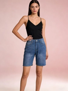 Front view of women's denim shorts with whiskering effect and black camisole