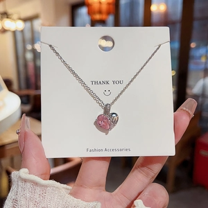 Détail du pendentif en cœur avec pierre rose et gravure argentée rétro