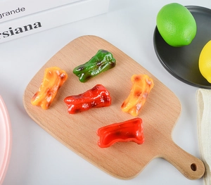 Detailed close-up of realistic faux bell pepper models on a rustic wooden cutting board