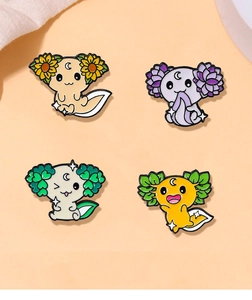 Dettaglio di quattro spillette axolotl con girasole, loto, quadrifoglio e motivi foglia