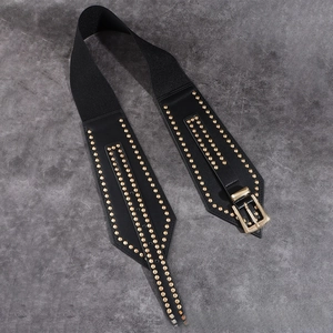 Detail of black elastic corset belt with gold studs and large metallic buckle