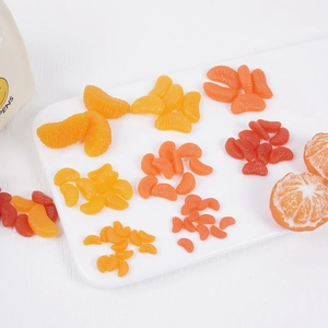 Miniatur-PVC-Orangenscheiben-Modelle in verschiedenen Größen und Farben auf weißem Tablett