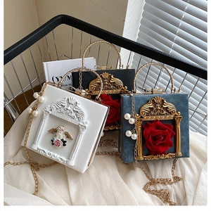 Close-up of Baroque style relief handbags with embossed angels and 3D roses detail