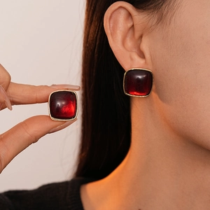 Maillard style square red resin earrings with gold-plated borders on model