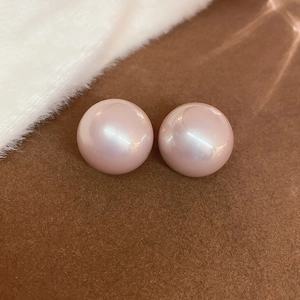 Vista macro dettagliata di grandi orecchini a perla tonda con lucentezza bianco rosa