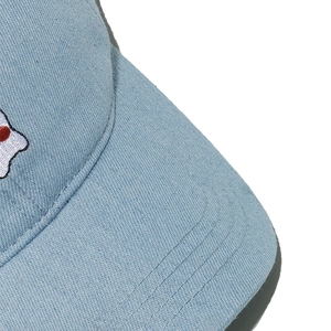 Close-up of light blue denim baseball cap showing fine stitching and cotton twill texture