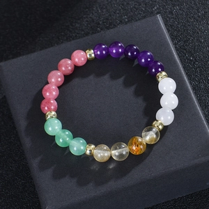 Bracciale di quarzo fragola e citrino naturale esposto su un portagioie nero di lusso