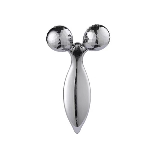 Macro detail of 3D V-face roller massager with silver diamond-cut metallic spheres