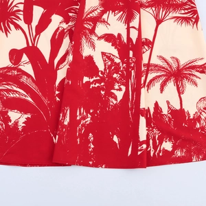 Robe de vacances imprimée cocotiers rouge et beige avec détail de l'ourlet fluide