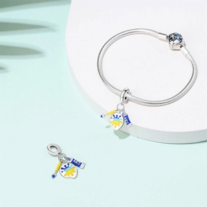 Detail of artistic silver bracelet with paintbrush, palette and ART paint tube charms