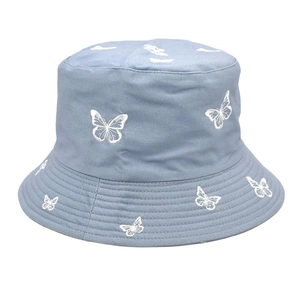Détails de broderie papillon blanc sur bob en coton bleu clair avec bord surpiqué