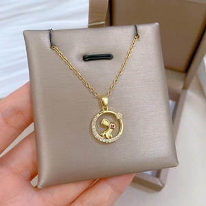 Detailed close-up of a gold necklace with a zircon-encrusted moon and red-eyed rabbit pendant