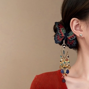 Pince à cheveux papillon brodée style chinois avec pompon en cristal sur un modèle