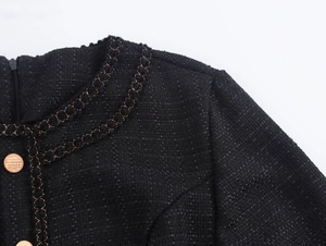 Dettaglio dell'abito in tweed con ricamo a catena dorata e bottoni testurizzati