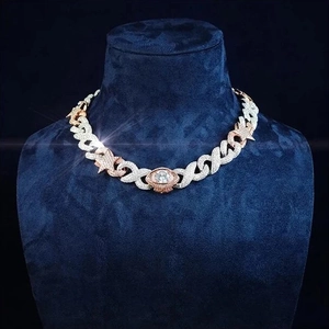 Close-up of hip hop Cuban link necklace with star links and iced-out eye pendant in two-tone