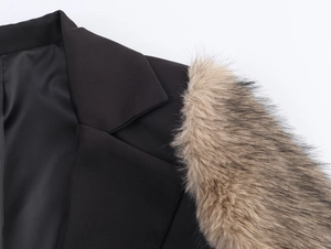 Detail of faux fur trim on shoulder of black oversized coat with luxury texture
