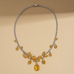 Close-up of butterfly pendant necklace with yellow waterdrop gemstone and pavé crystals