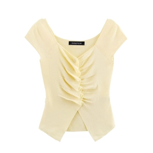 Close-up of light yellow knit top featuring V-neckline and decorative ruched detailing