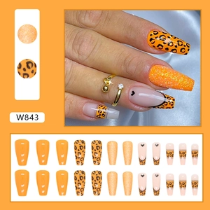 Orange leopard print press-on nails with glitter accents and French heart designs