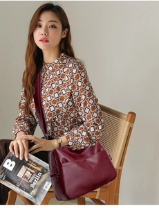 Detail view of burgundy PU leather bag with lychee texture and side zipper pocket