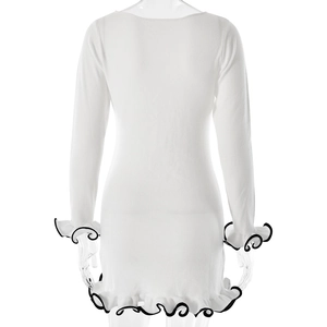 Detailed back view of white long sleeve knit dress with black ruffled hem and cuffs