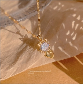 Detailed close-up of a gold cat necklace with a brilliant round cubic zirconia stone