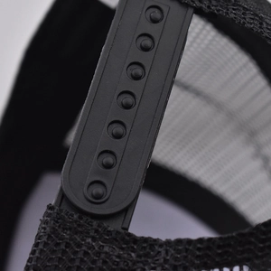 Detail of adjustable snapback closure on black mesh trucker hat for a custom fit