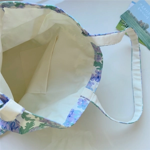 Détail du sac cabas floral montrant la poche intérieure et le tissu en toile de haute qualité