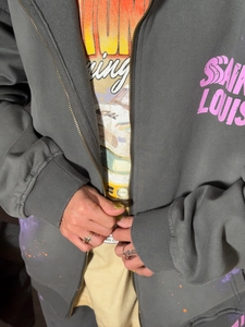 Détail du sweat à capuche gris foncé avec imprimé rose Saint Louis et tee-shirt
